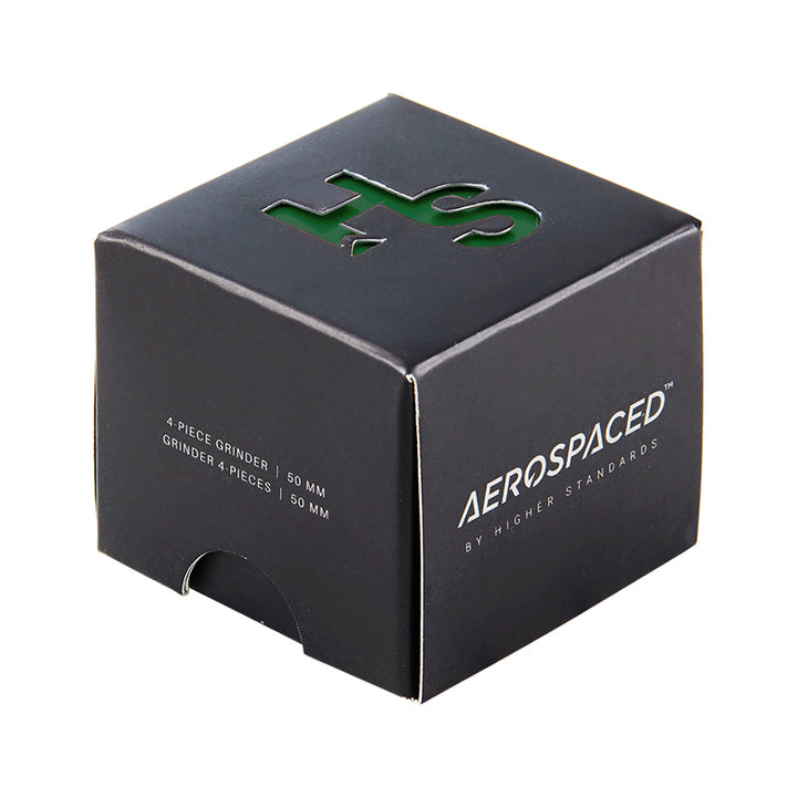 A Green 4 piece grinder inside its black box packaging. 
