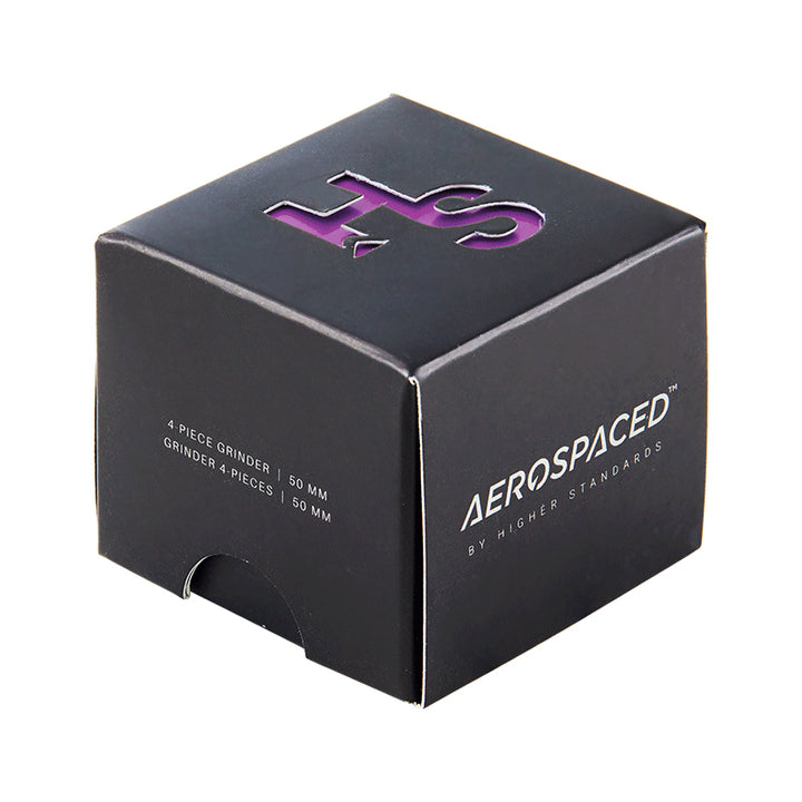 A Purple 4 piece Aeropspaced grinder inside it's packaging, against a white background.